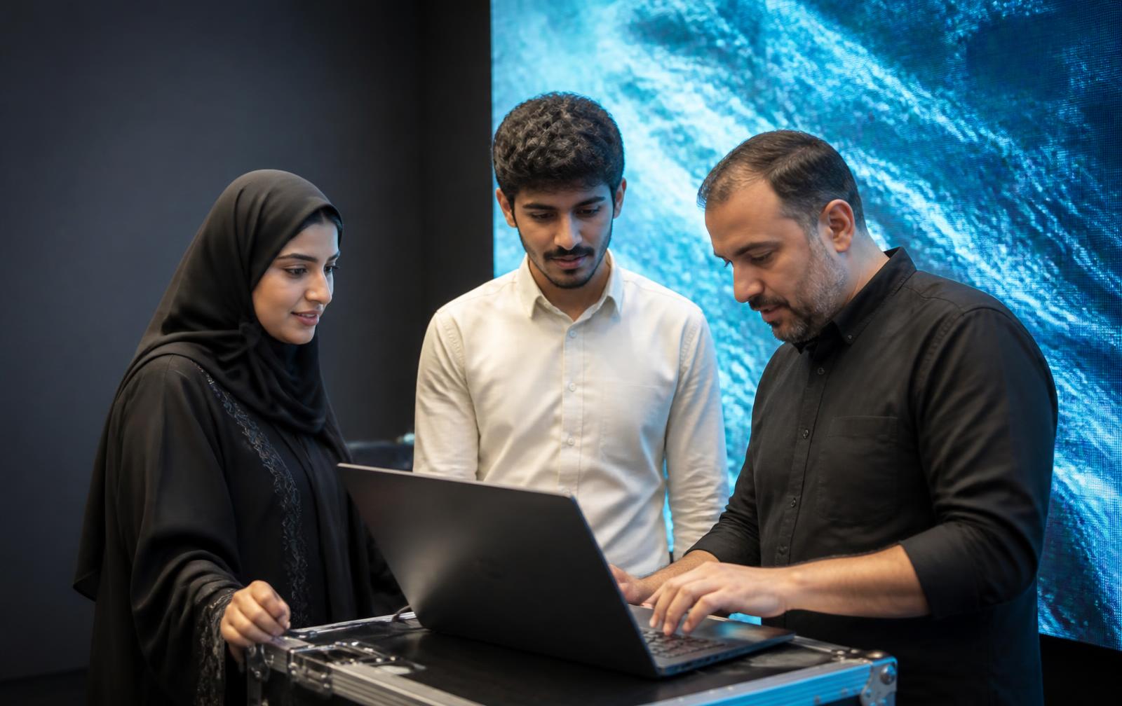 Saudi university students reviewing an LED display demonstration with a CaesarTechs engineer